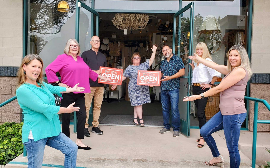 black whale home staff photo at showroom entrance with open signs